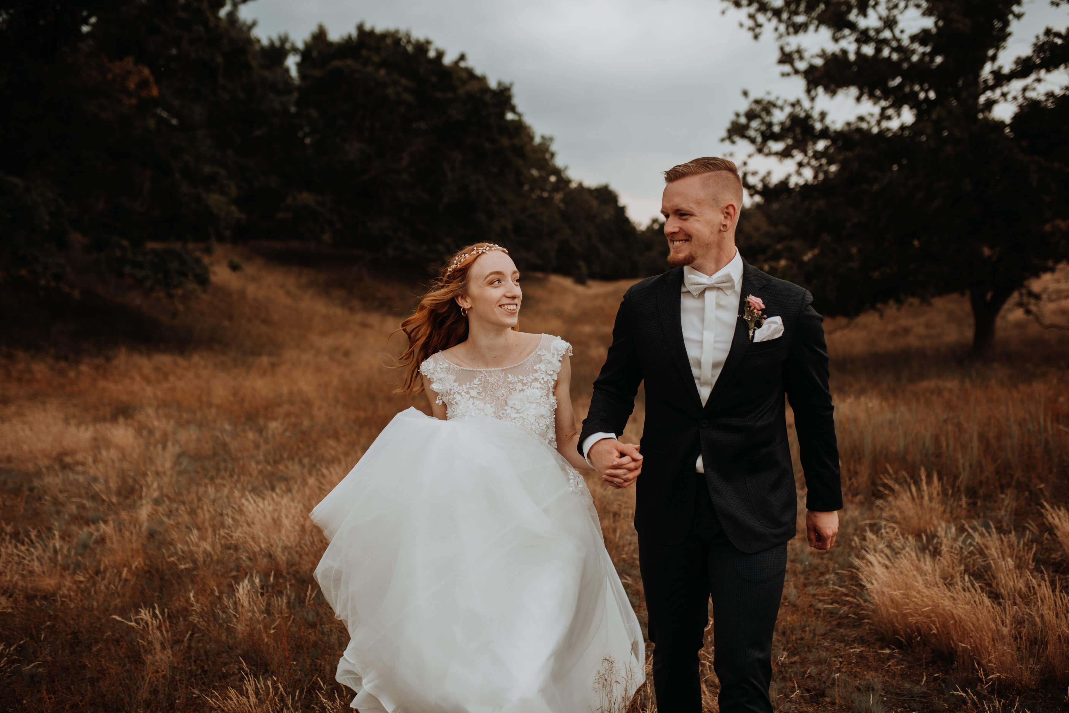 Braut und Bräutigam laufen in den Dünen in Altwarp