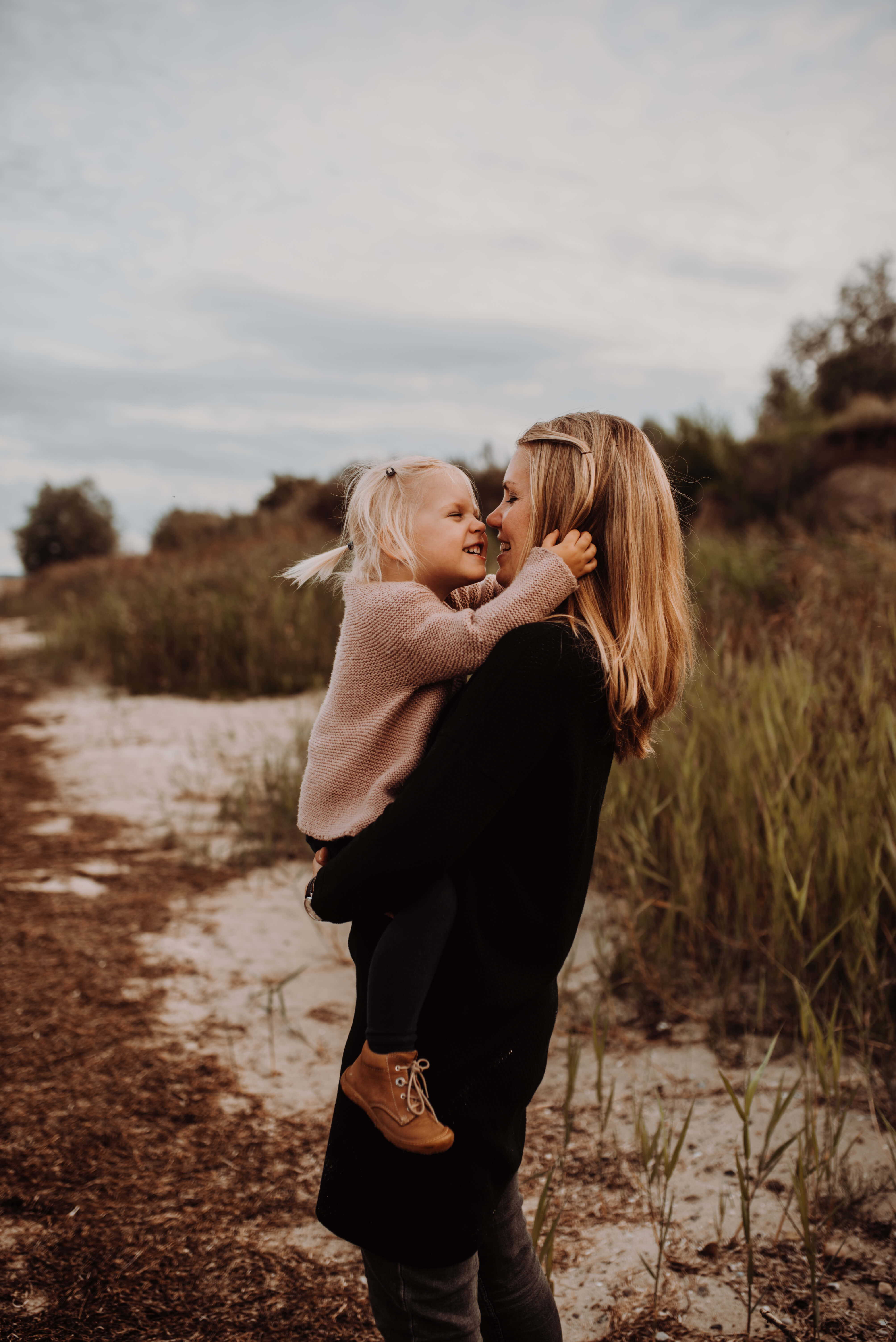 Mutter hält Tochter in der Natur auf dem Arm Sie kuscheln Nase an Nase